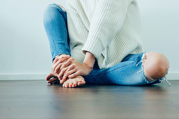 Jeune femme assise sur parquet avec plancher chauffant